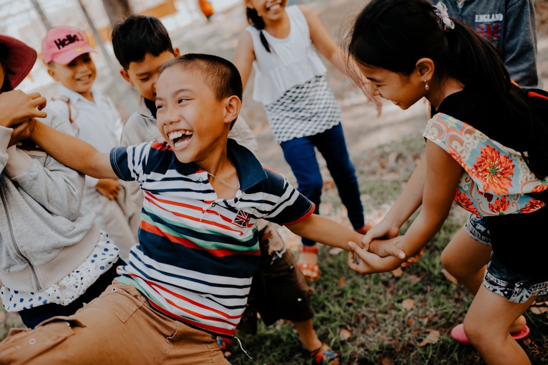 Photo by MI PHAM children playing on grass field